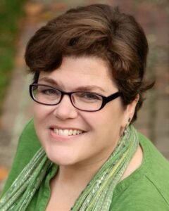 Woman wearing green top and scarf.